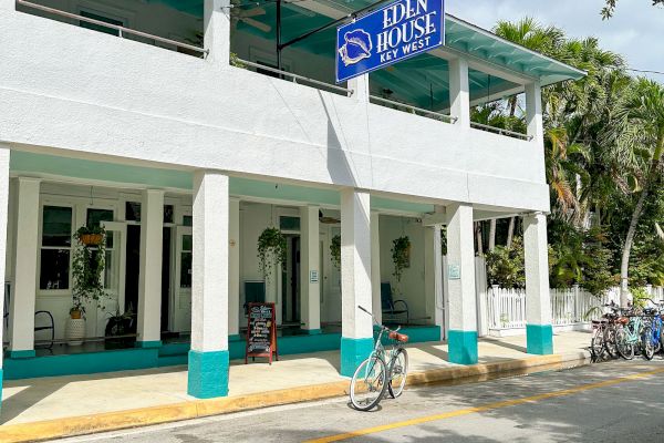 A white two-story building with teal accents and a blue sign reads 